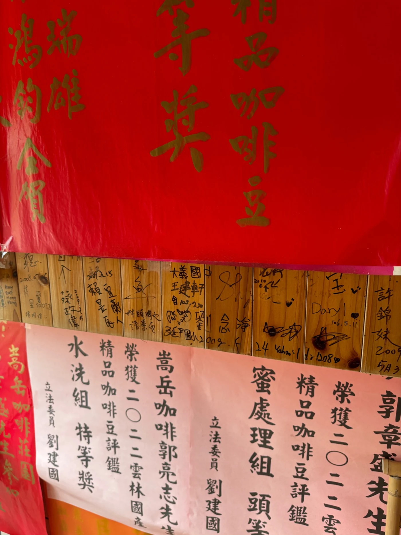 Traditional red and bamboo walls at a Taiwanese coffee destination covered with handwritten names and calligraphy